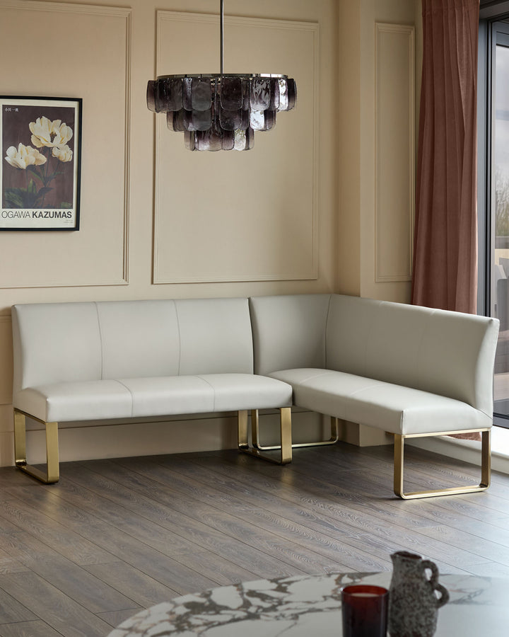 Light grey faux leather corner dining bench with brushed brass legs in modern living room setting.