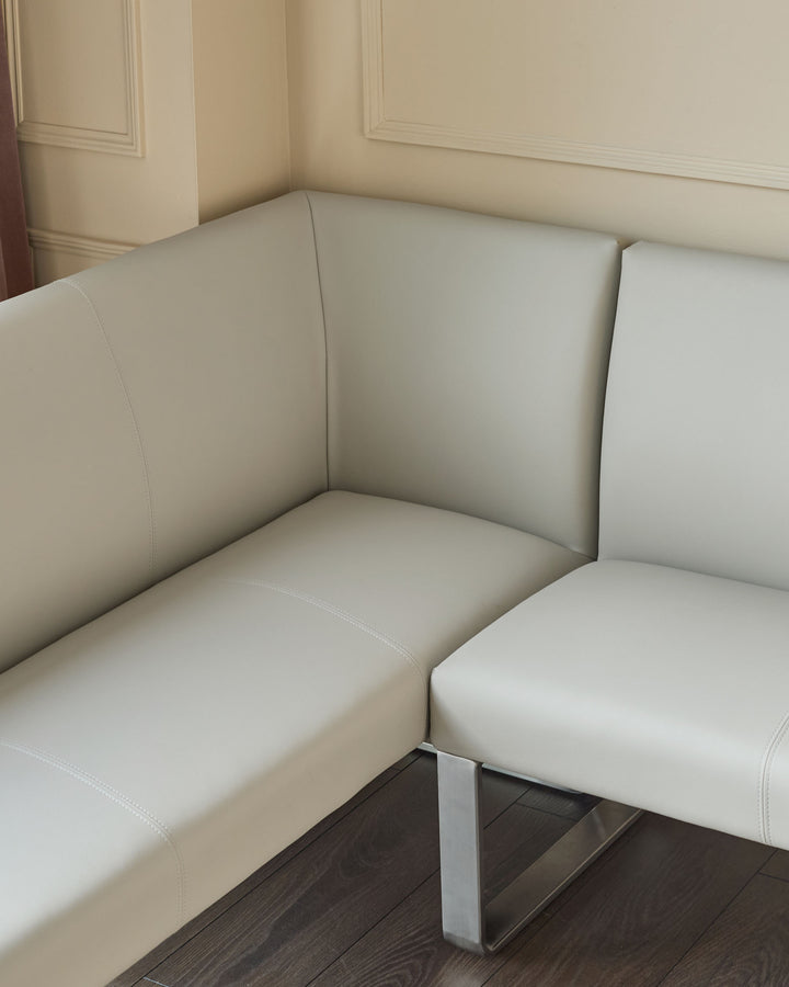 Light grey faux-leather right-hand corner bench with stainless steel base, showing curved seating sections and stitched details.