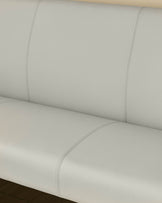 Light grey upholstered corner bench with curved seating, stitched seams, and black legs, shown from close-up angle.