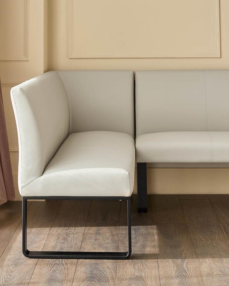 Light grey corner bench with black metal legs, shown at an angle in a neutral room setting.