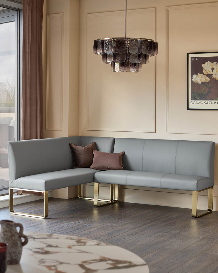 Loop 5-seater corner dining bench in mid-grey faux leather with brushed brass legs, shown in a modern living room setting.
