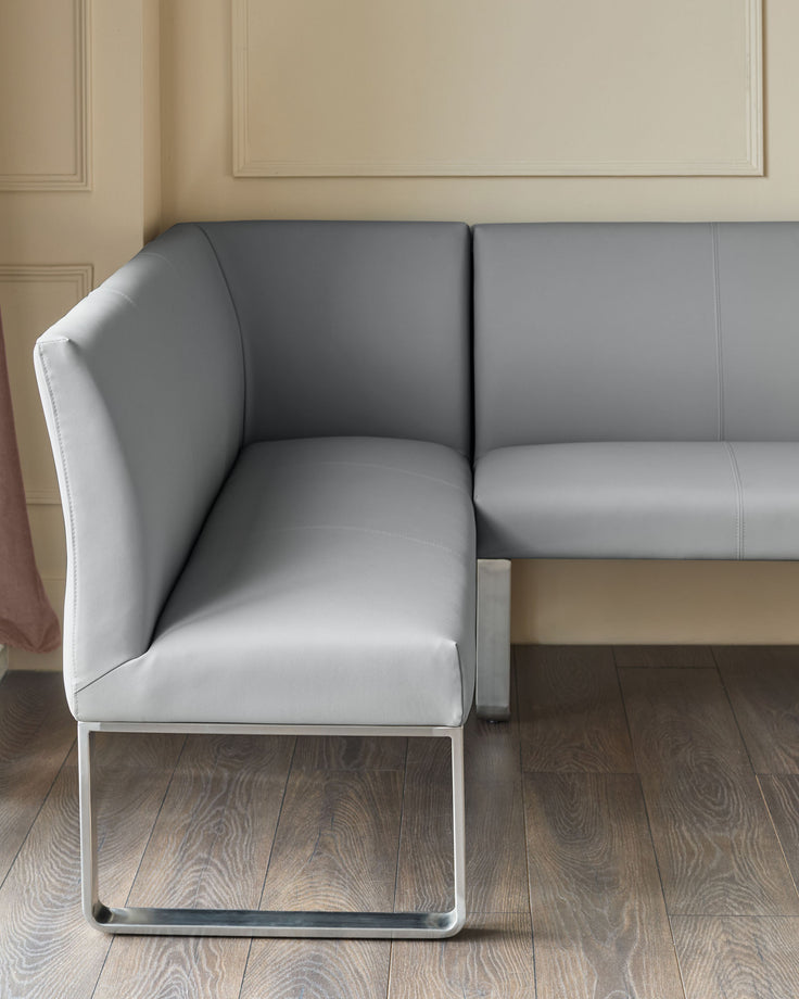Grey faux-leather left-hand corner bench with stainless steel frame, viewed from side angle in neutral interior setting.