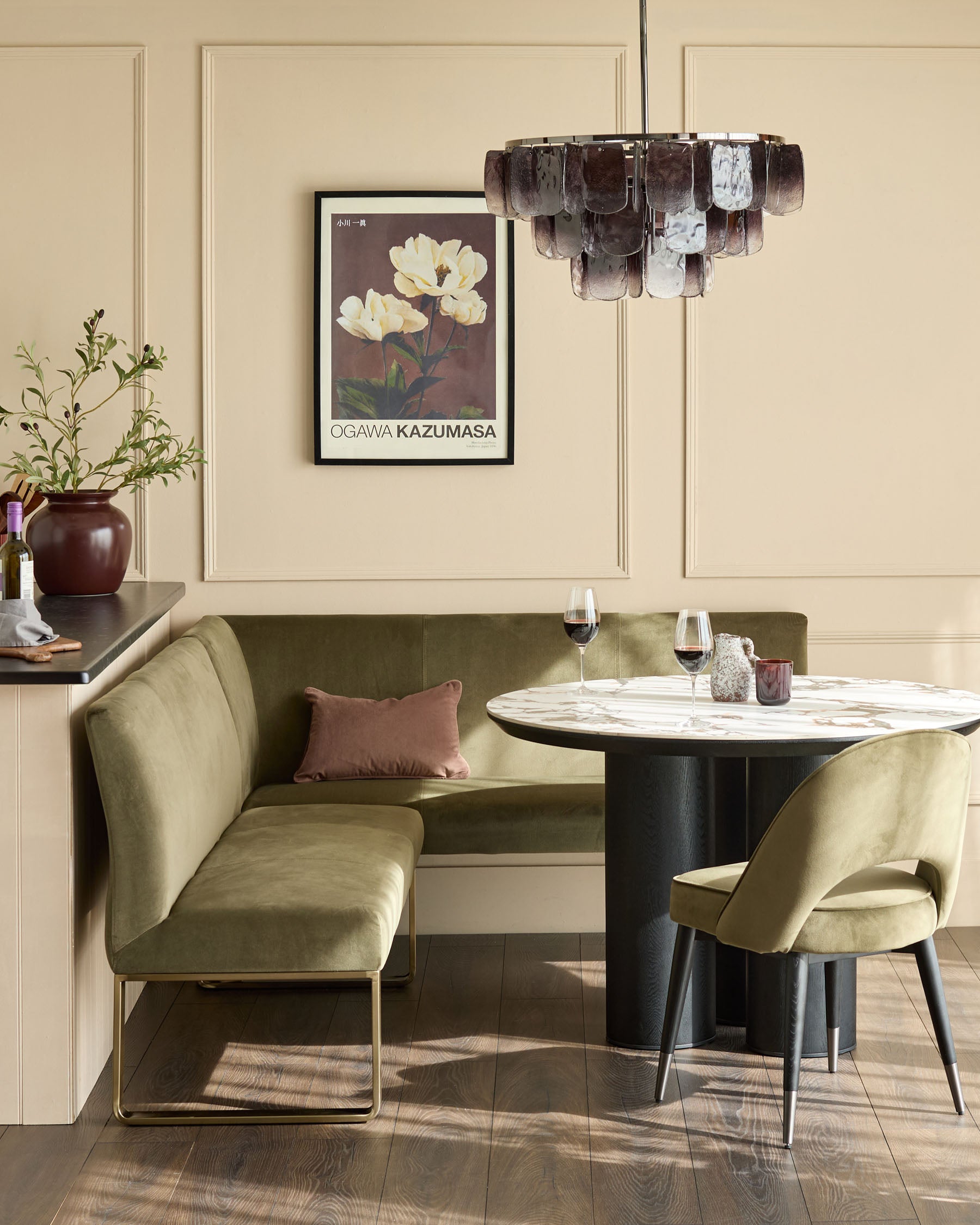 Smoked ombre glass chandelier with cylindrical shade in brown and white tones, suspended above a dining table.