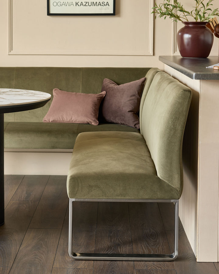 Loop 5-seater right-hand corner bench in olive green with stainless steel legs, styled with decorative pillows.