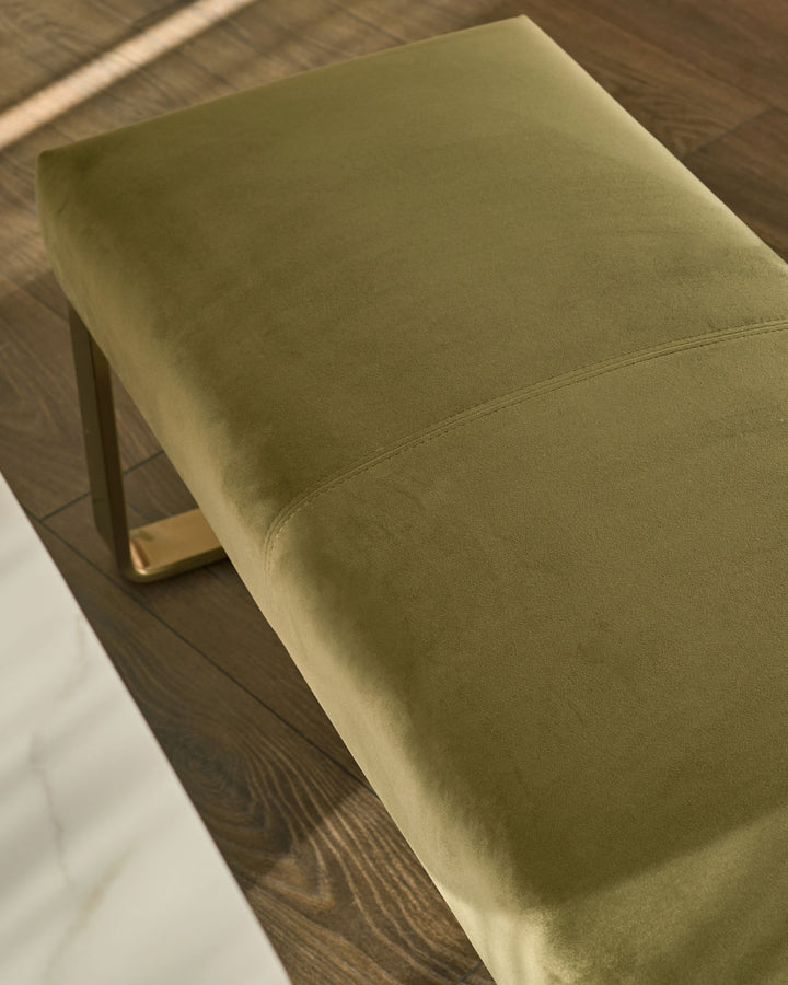 Olive green velvet bench with brushed brass legs, viewed from above at an angle.