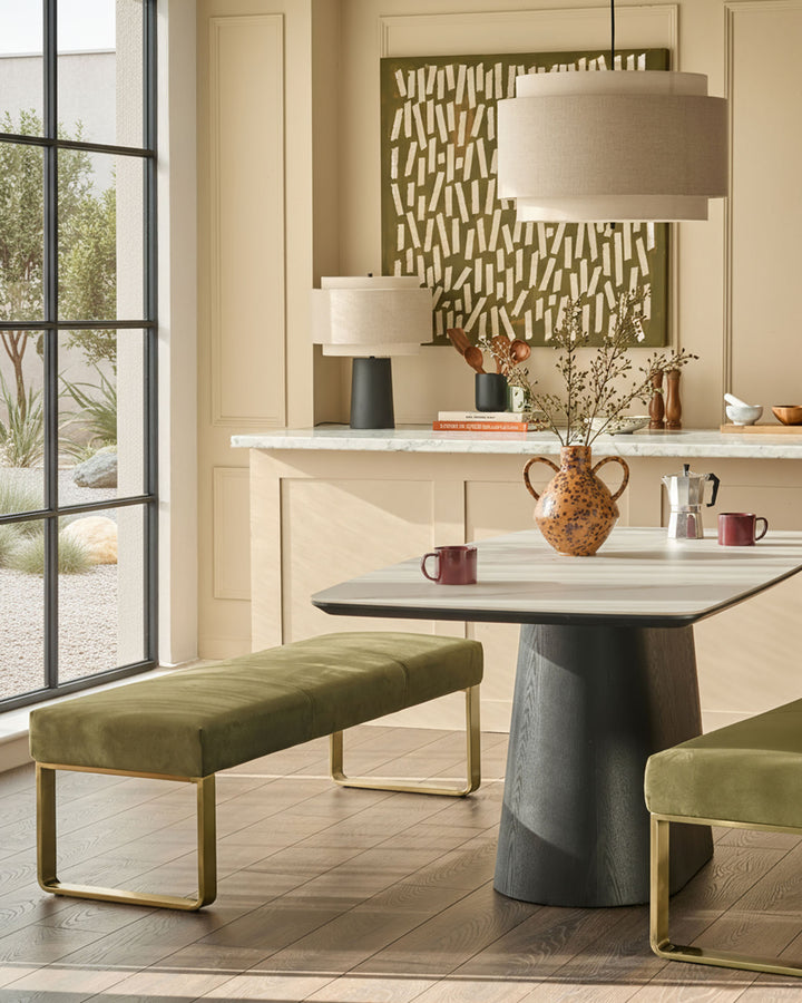 Loop 3-seater velvet bench without backrest in olive green with brushed brass frame, shown in dining setting.