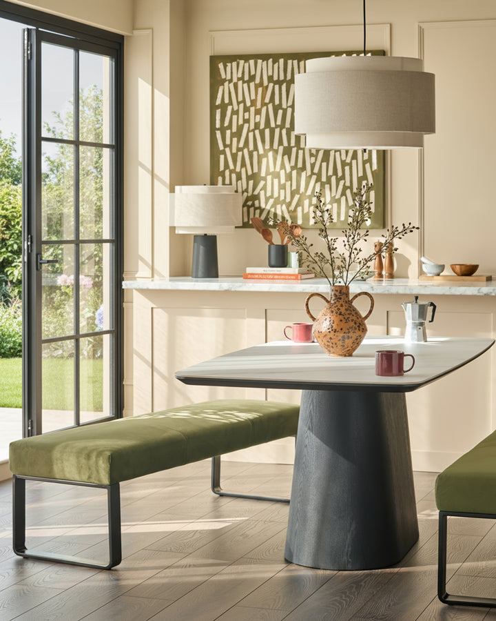Loop 3-seater velvet bench without backrest in olive green with black metal frame, shown in modern dining setting.