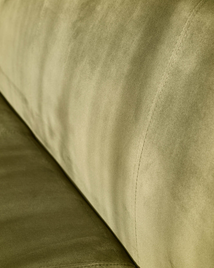 Olive green velvet bench close-up showing smooth fabric texture and stitched seam detail.