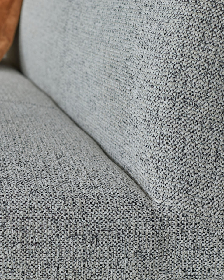 Grey fabric 3-seater bench with backrest, close-up detail of textured upholstery and black metal frame.