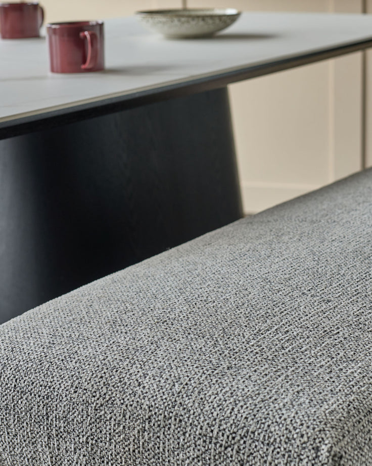 Grey fabric 3-seater bench without backrest, brushed brass frame, viewed from low angle showing textured upholstery.