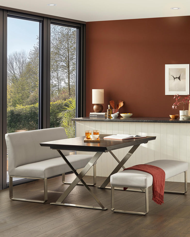Dining space with seating benches and a wood-look table. Brown feature wall and dark wood flooring.