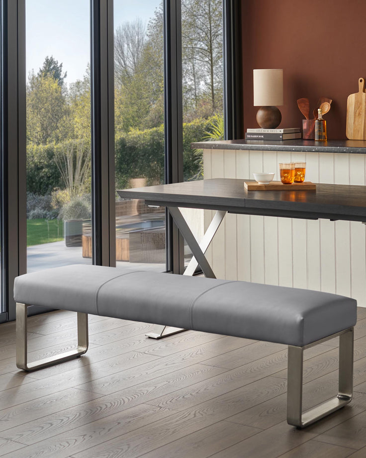 A grey bench sits by a table, illuminated by natural light pouring through large windows. Perfect for the modern dining room.
