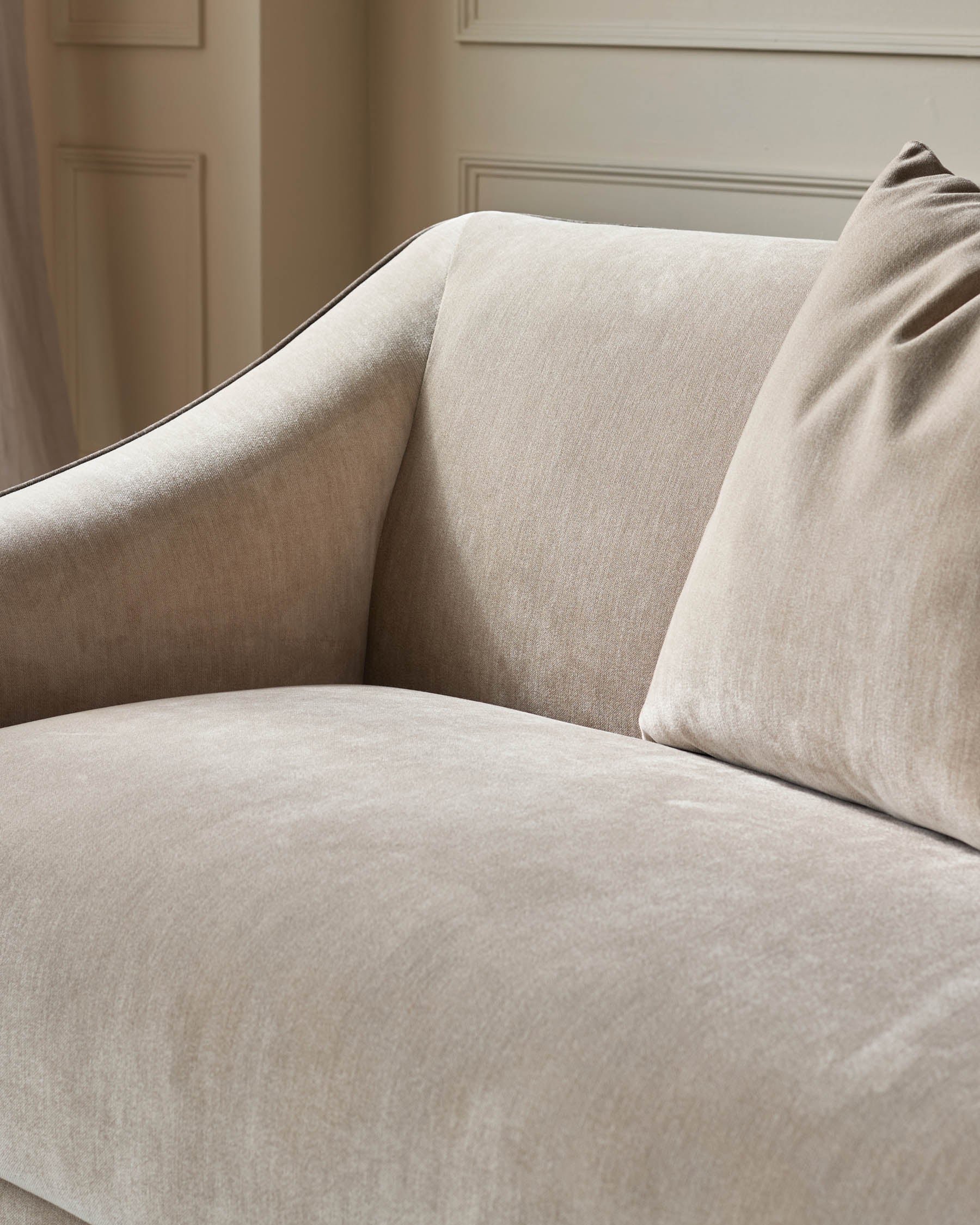 Champagne fabric 3-seater sofa with curved arms and back cushions, shown at an angle in a neutral interior setting.