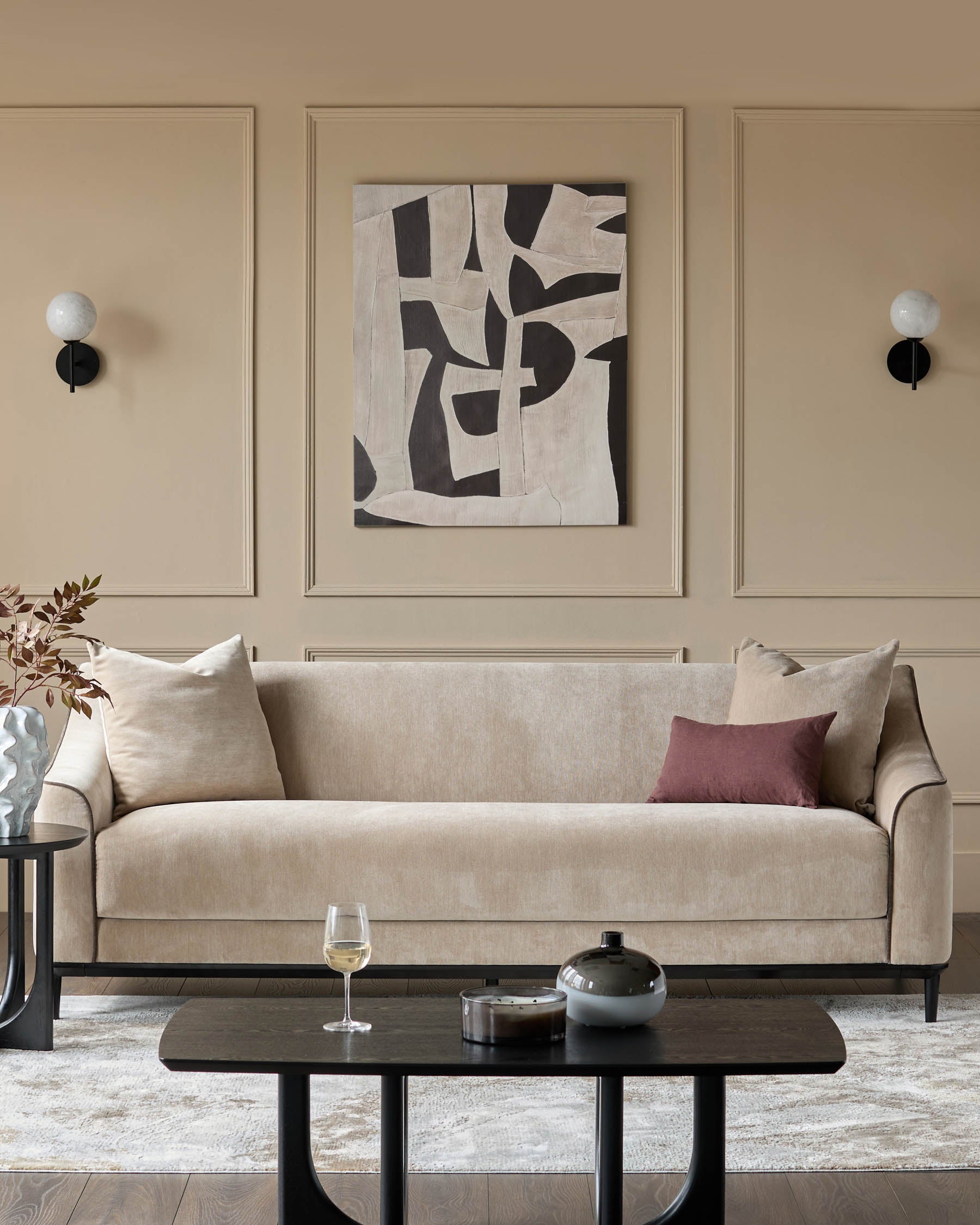 Champagne fabric three-seater sofa with curved arms and dark wooden legs in a modern living room setting.