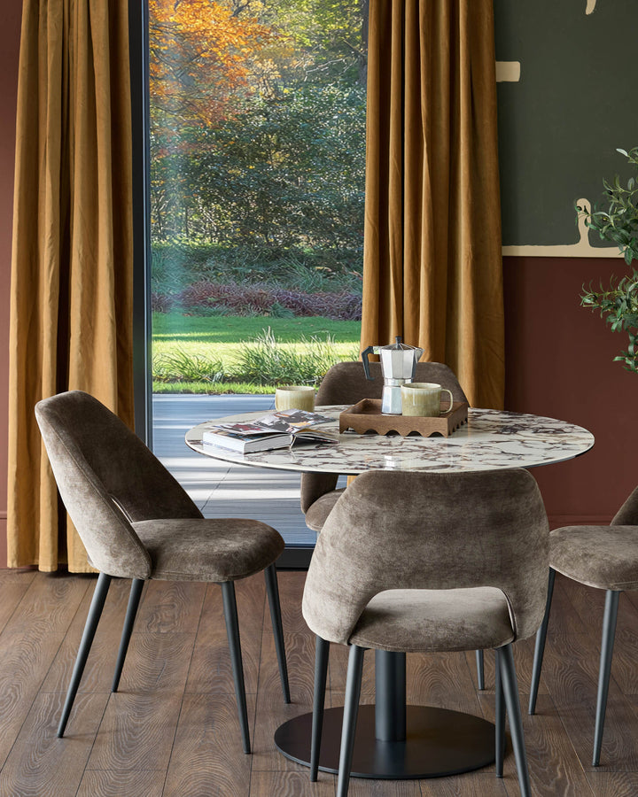 A stylish dining set featuring a round marble table and four upholstered chairs, perfect for a contemporary dining room.
