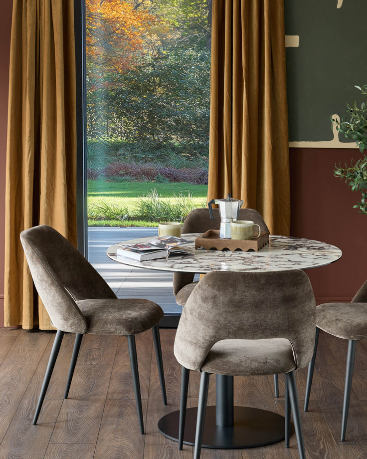 A stylish dining set featuring a round marble table and four upholstered chairs, perfect for a contemporary dining room.