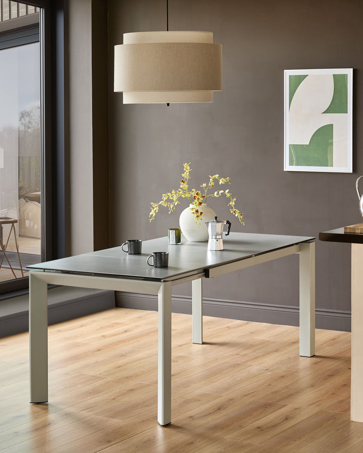 Louis ceramic extending dining table in light grey with black top, shown in modern kitchen setting.