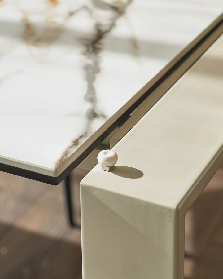 Close-up of a stylish table with a white marble top and pale frame, showcasing modern design and quality craftsmanship.