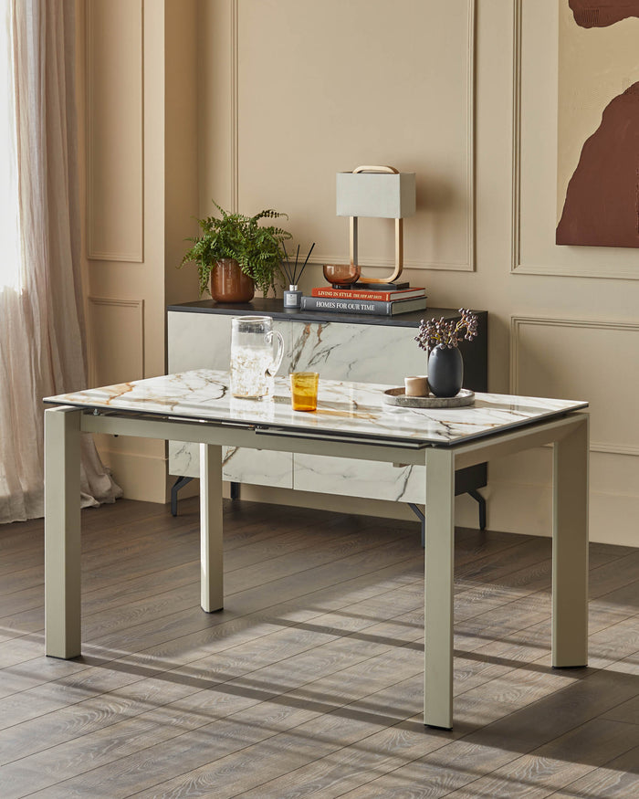 A stylish dining table with a marble top and modern legs, complemented by a sideboard and decorative items.