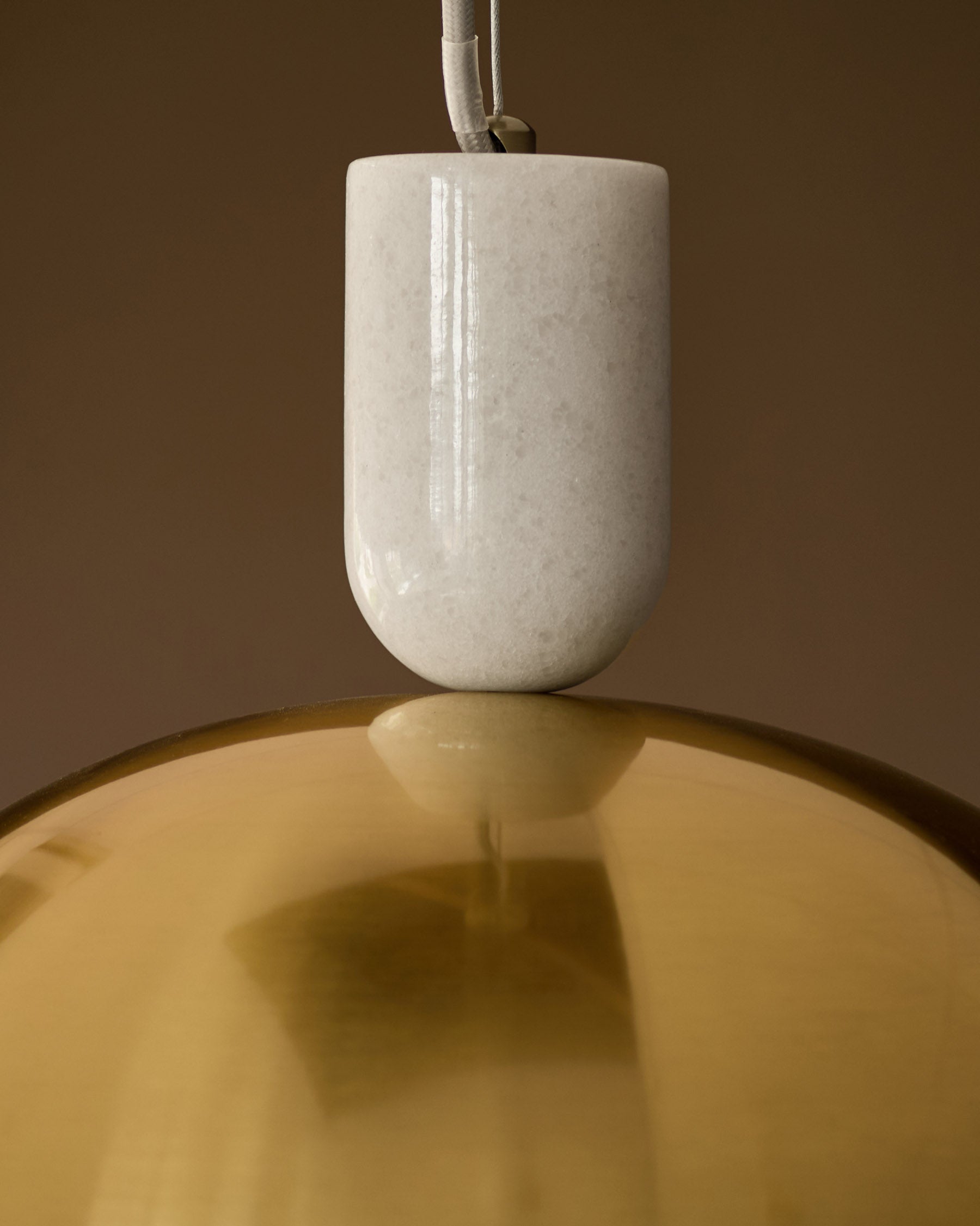Louis single pendant light with cream ceramic shade and brass bowl, suspended by white cord against neutral background.