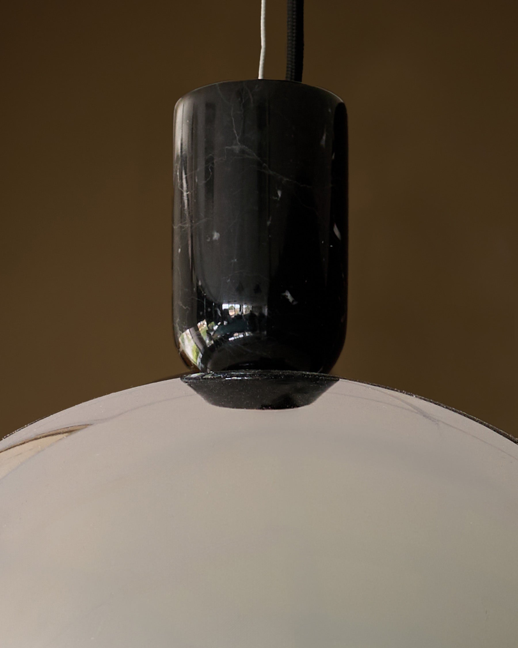 Louis single pendant with black chrome finish and white dome shade, hanging against neutral background.