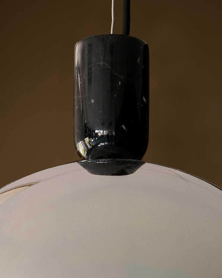 Louis single pendant with black chrome finish and white dome shade, hanging against neutral background.