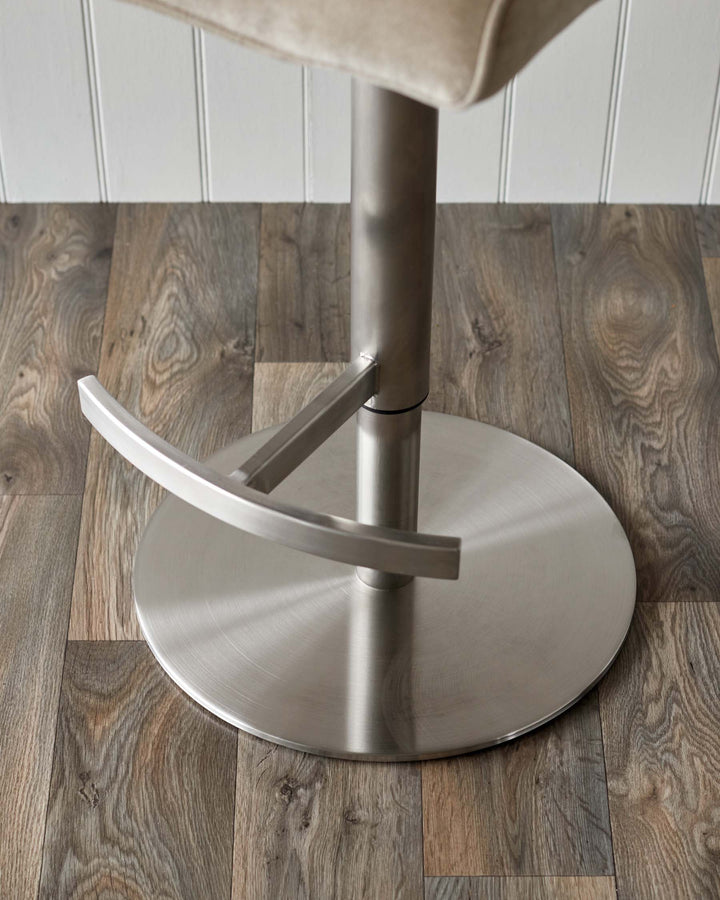Close-up of a stylish bar stool with a brushed metal base, showcasing its modern design and quality craftsmanship.