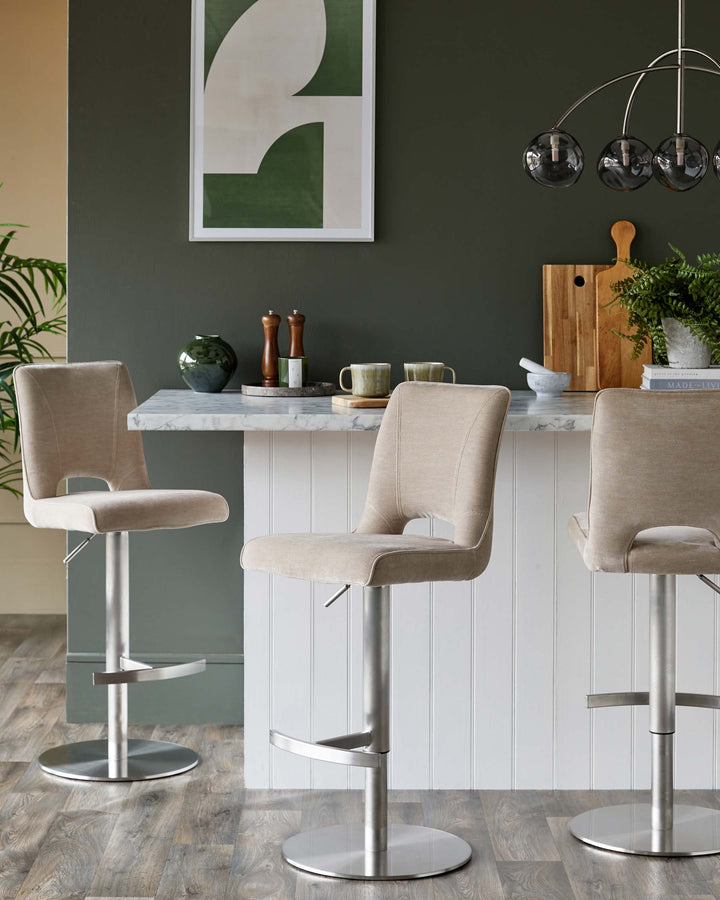 Three beige bar stools with brushed steel bases at a breakfast bar, creating a stylish kitchen setting.