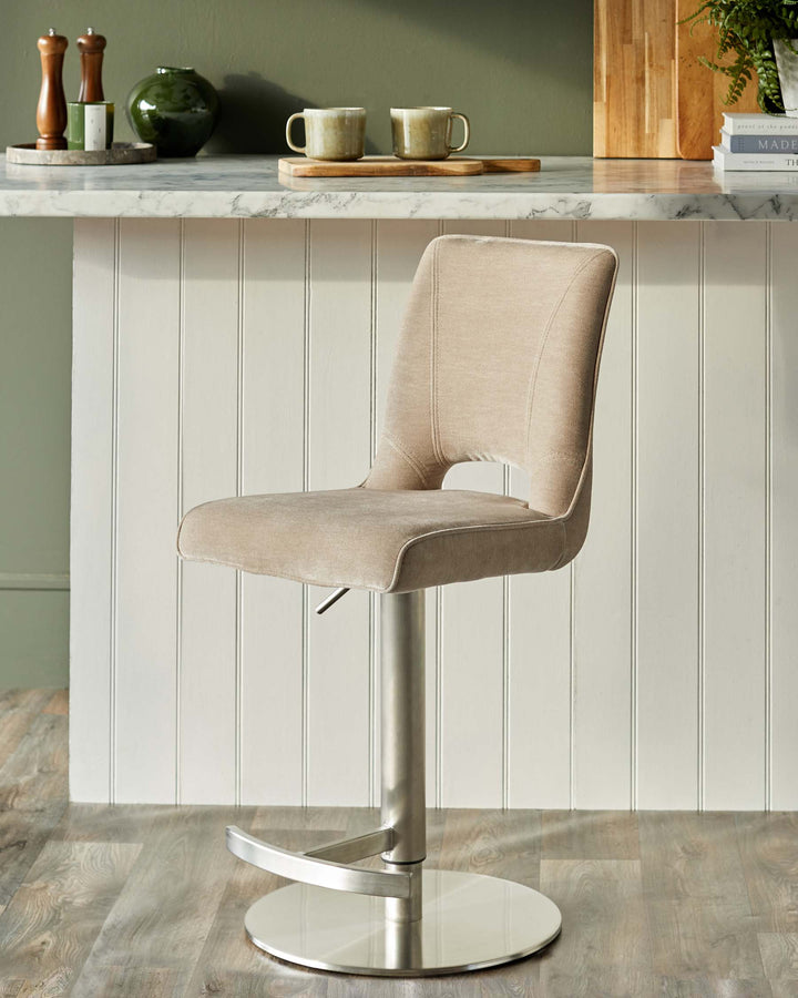 A modern, brushed metal bar stool with a square, padded seat and back in a neutral fabric. Contemporary and stylish.