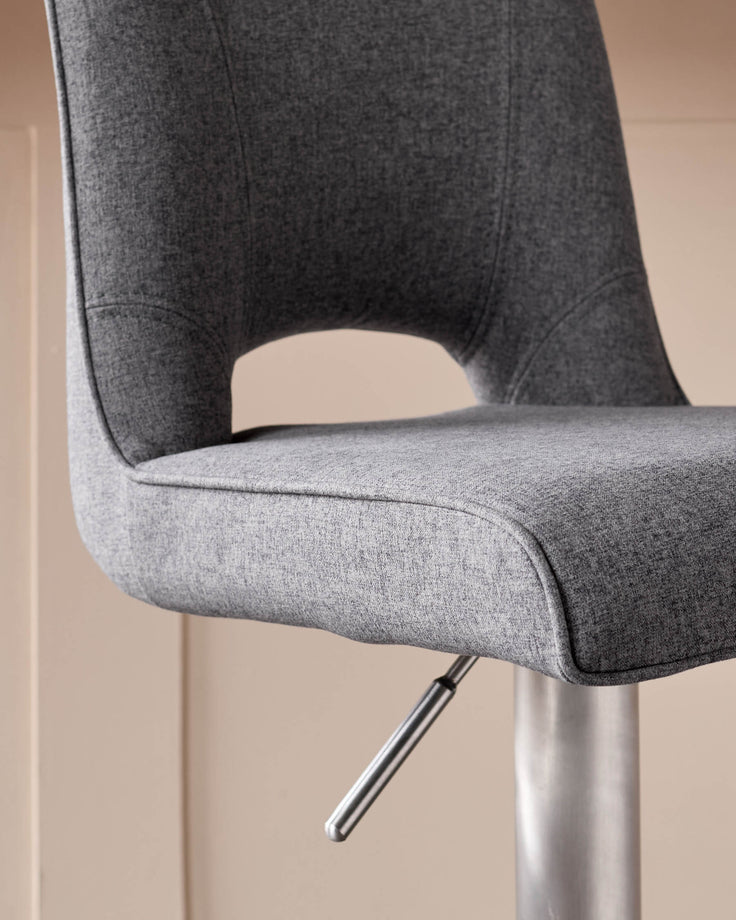Dark grey fabric gas lift bar stool with curved backrest and chrome metal base, side view.
