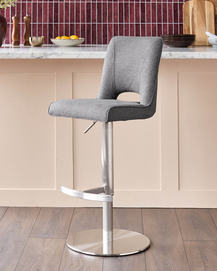 Dark grey fabric gas lift bar stool with curved backrest and chrome base, shown at kitchen island.
