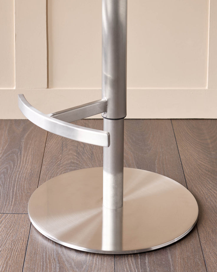 Modern bar stool with white fabric seat, silver metal pole and base, curved armrest detail visible.