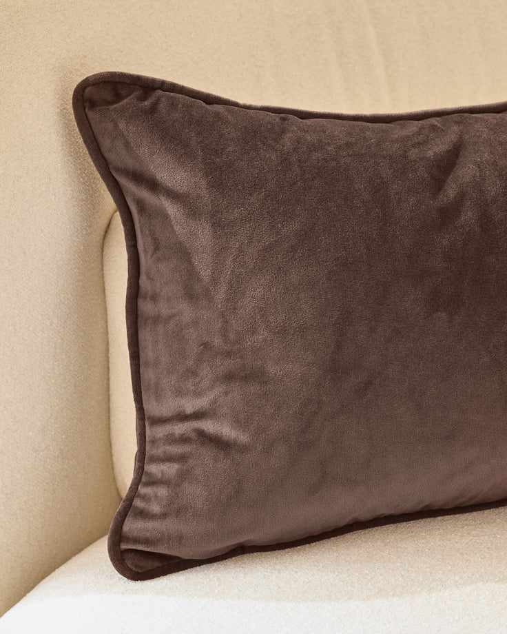 Luca rectangle cushion in chocolate brown velvet with piped edges, displayed on a cream background.