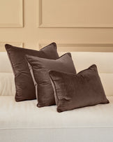 Luca Rectangle Cushion in Chocolate displayed on cream sofa, shown in set of three varying sizes.