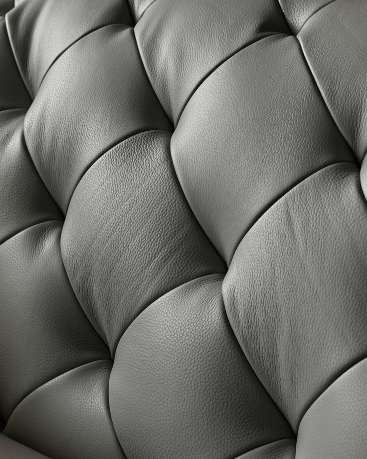 Close-up of grey woven leather upholstery, possibly a chair or sofa detail, showcasing texture and design.