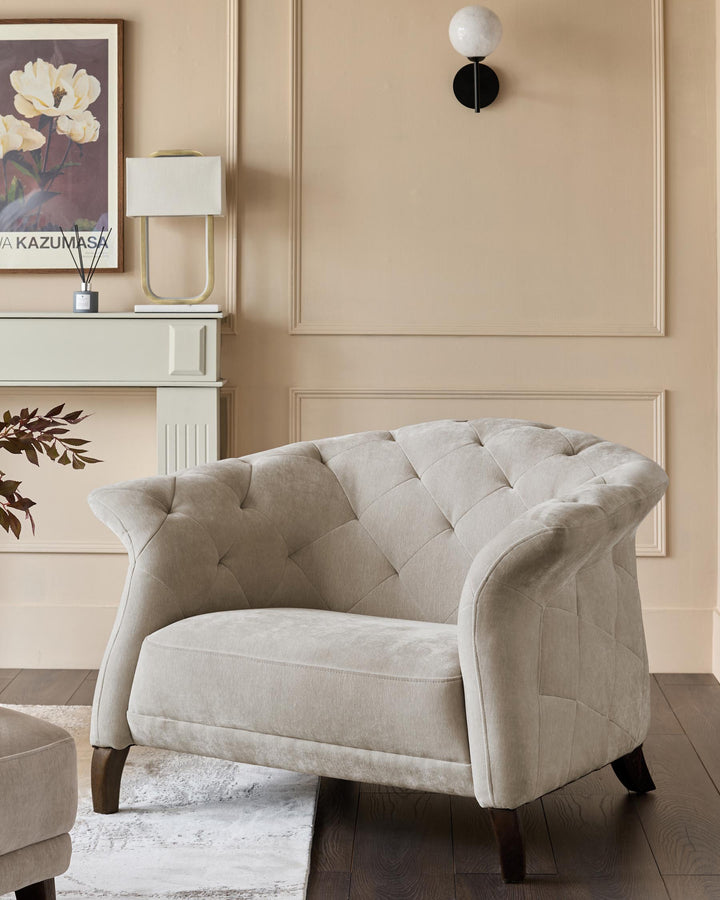 A button-backed armchair takes centre stage, complemented by a lamp, art, and a fireplace, creating a cosy and stylish ambiance.