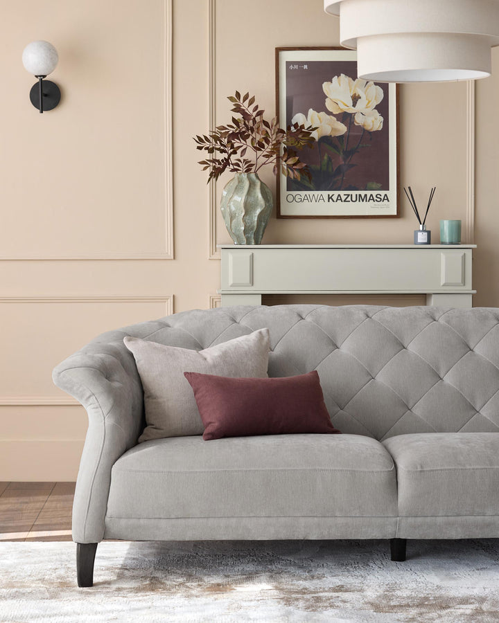 A plush, light-grey sofa sits beneath a stylish display unit in a warm, inviting living room setting.