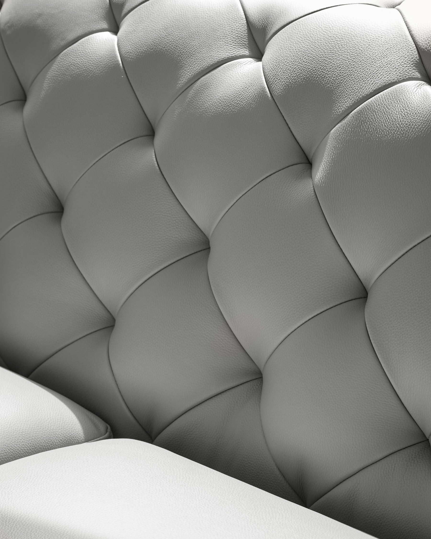 Close-up of luxurious, tufted grey leather sofa. Elegant design, perfect for adding style to any living space.
