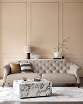Elegant living room with button-tufted sofa, marble coffee table and wall-mounted console table.