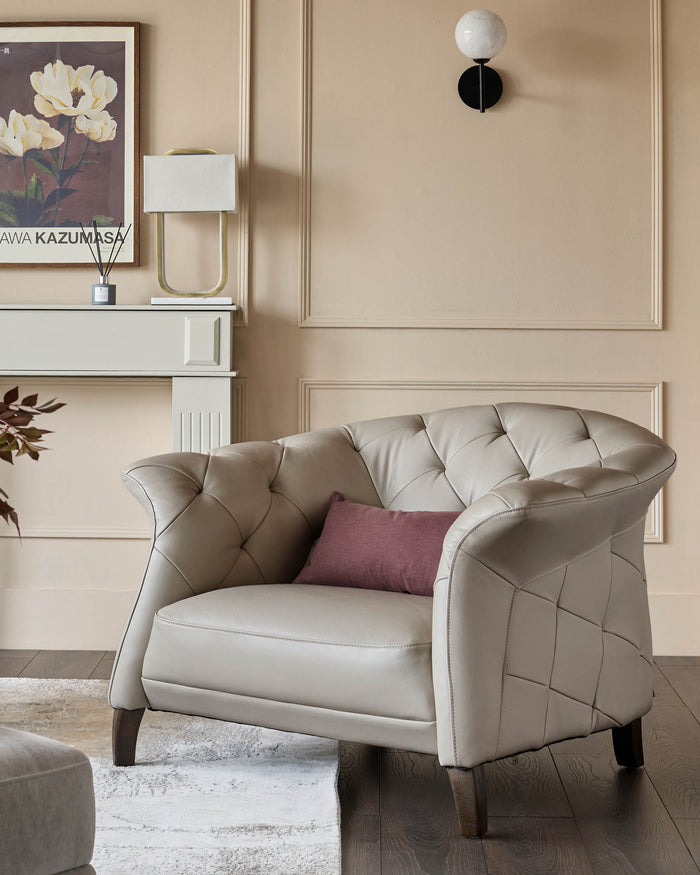 A luxurious leather armchair with a button-tufted back and a plum-coloured cushion. The chair has dark wood legs.