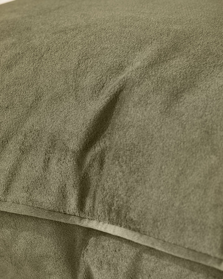 Close-up of Luca medium cushion in olive green, showing textured fabric and soft folds.