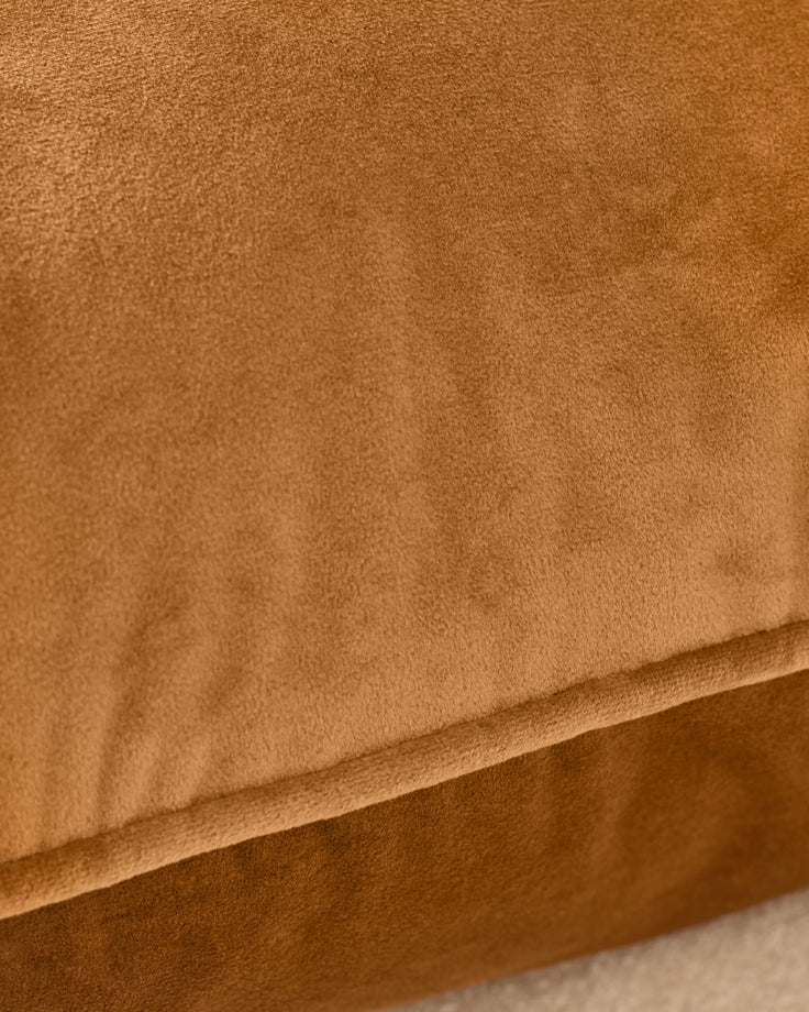 Close-up of caramel suede fabric on the Luca large cushion, showing soft texture and fold detail.