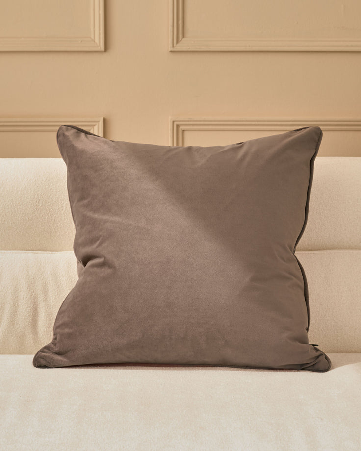 Luca cushion in mink, large square pillow with piped edges on cream upholstered bed.