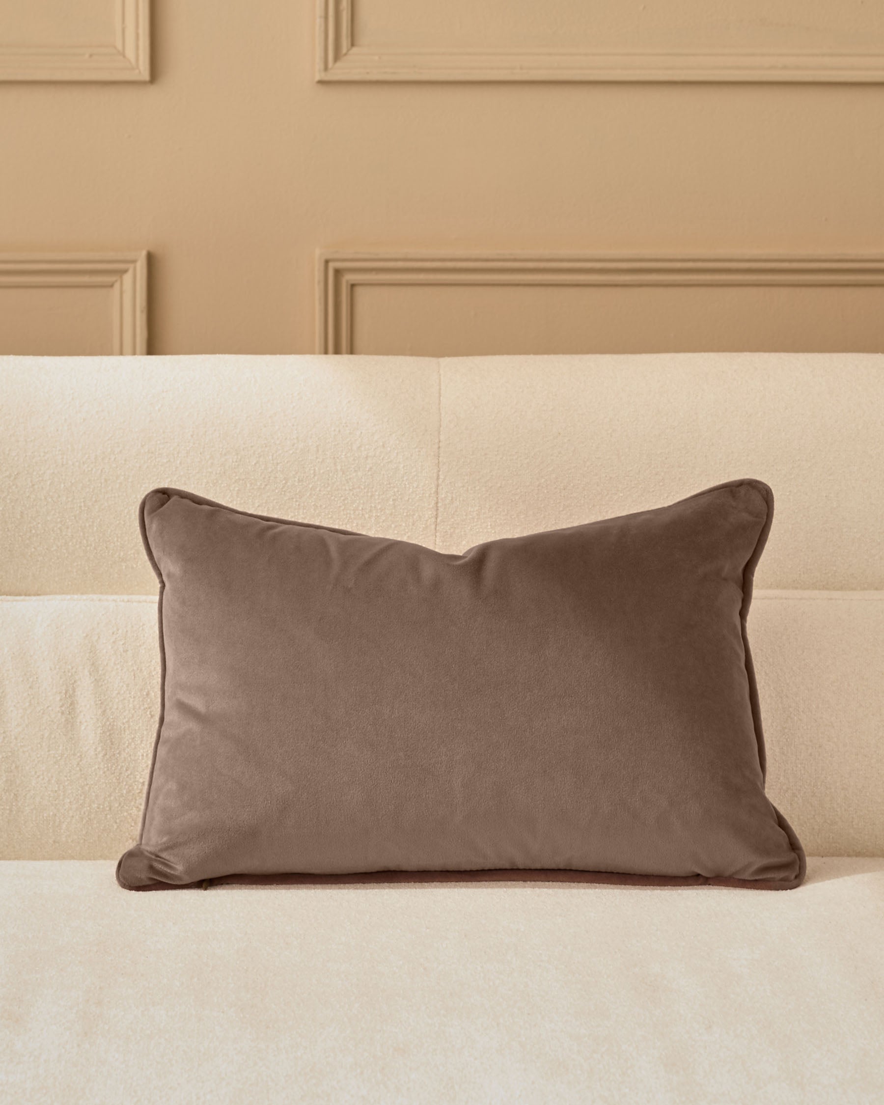 Mink velvet rectangular cushion with piping, displayed on a cream upholstered headboard.