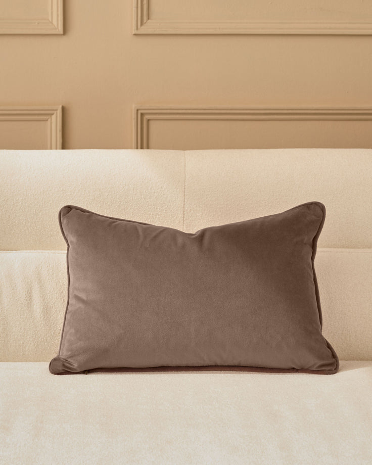 Mink velvet rectangular cushion with piping, displayed on a cream upholstered headboard.