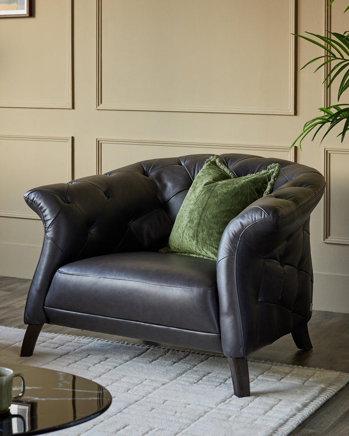 A luxurious dark leather armchair with a green cushion, placed on a cream patterned rug.