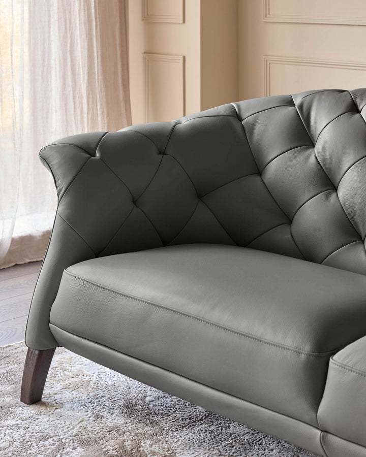 Close-up of a grey leather sofa with a tufted back and wooden legs. Elegant design for a modern living space.