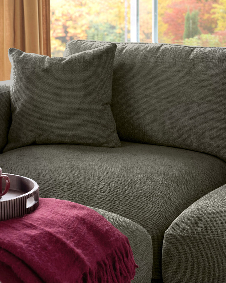Lynetta 3-seater sofa in dark green weave fabric with scatter cushions, shown in a bright room with autumn views.