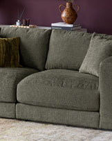 Lynetta 3-seater sofa in dark green weave fabric with cushions, styled with throws and decorative items on the back.