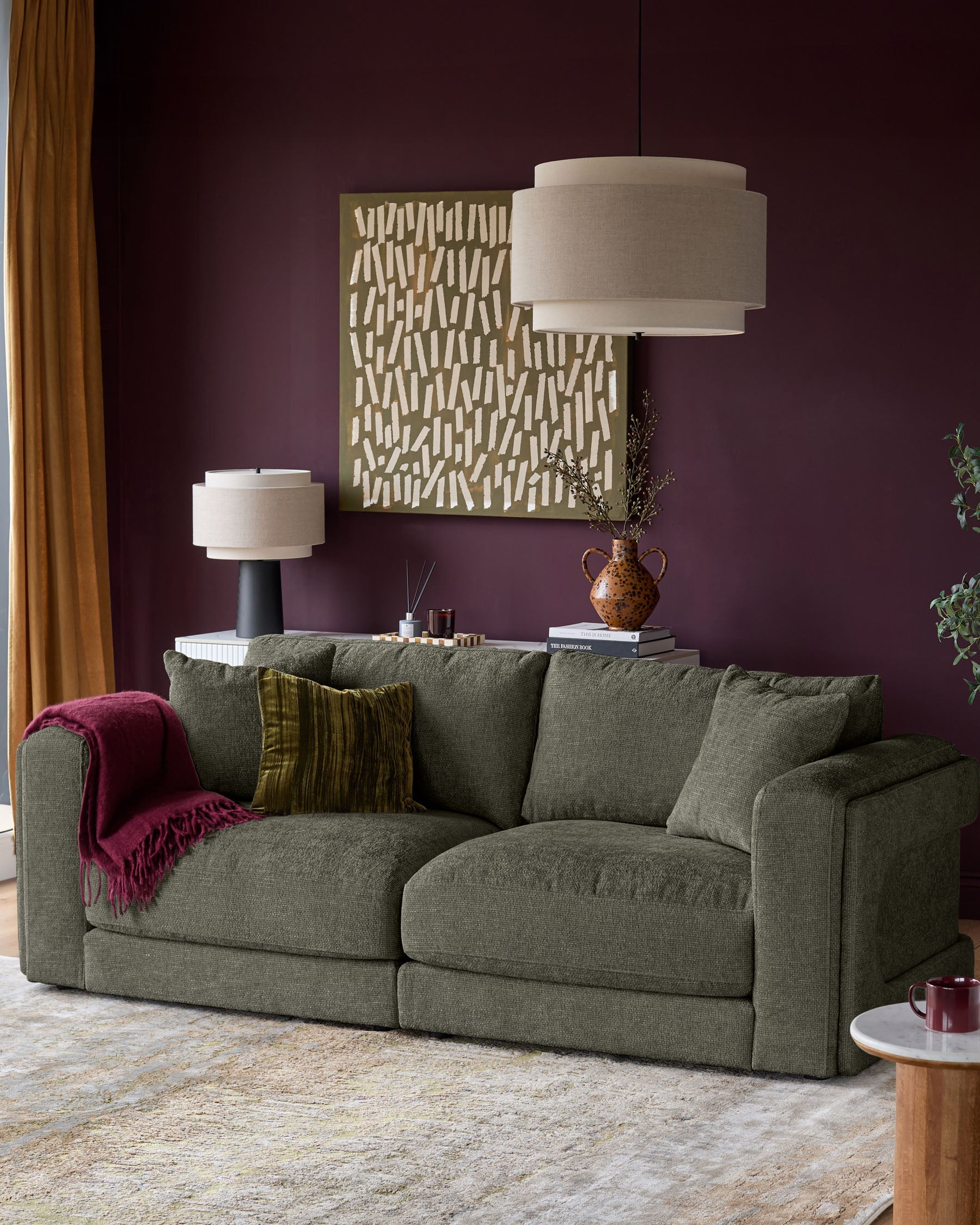 Lynetta 3-seater sofa in dark green weave fabric, displayed in a styled living room setting with cushions and a throw blanket.